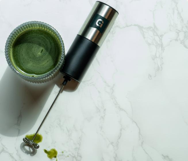 An image of a frother and a glass of greens